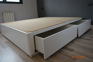 Cama canapé de madera acabado luxe lacado en color blanco grisaceo con esquinas redondas con cuatro cajones iguales